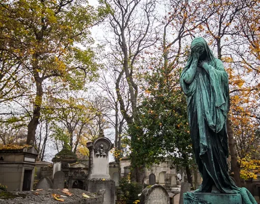 City of Immortals: Père-Lachaise Cemetery, Paris: New Book Celebrates the Rich and Beautiful History of the World’s Most Famous Cemetery A weathered statue stands among the tombstones in Pére Lachaise Cemetery