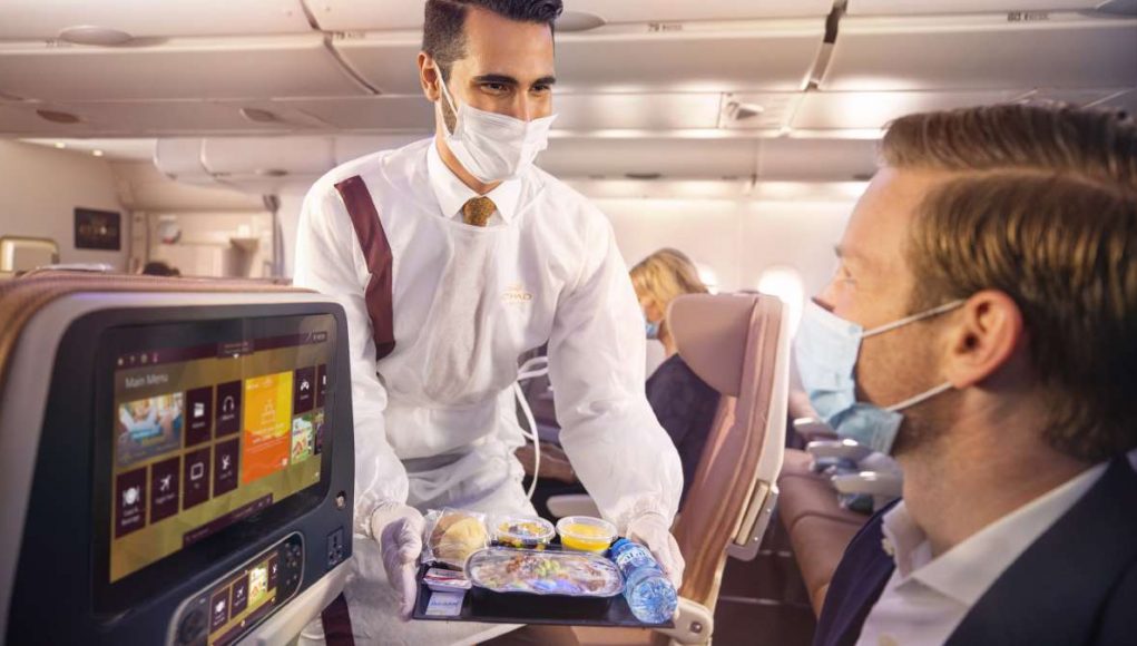 Etihad Crew onboard with PPE serving guests