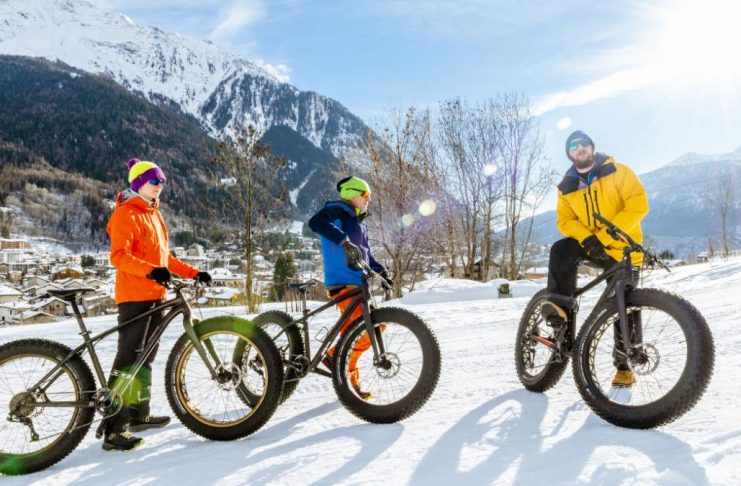 a group of people riding on fat tire bikes