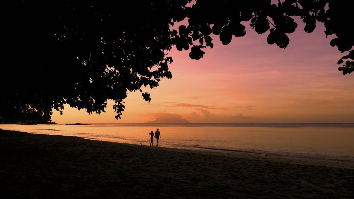 walking on the beach at sunset in the Seychelles