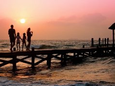 How to Play it Safe on Your Summer Vacation family on pier at sunset
