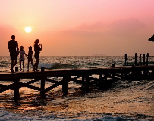 How to Play it Safe on Your Summer Vacation family on pier at sunset