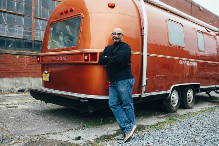 man standing beside his RV trailer