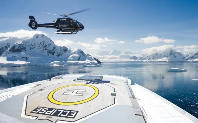 helicopter landing on the front of a luxury cruise ship