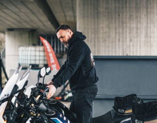 How To Safely Move Your Beloved Two-wheeler Across Country person getting his motorcycle ready for a cross country trip