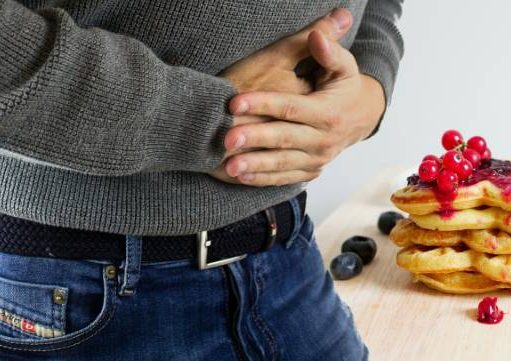 How to Avoid Food Poisoning When You Travel Abroad person hold thier stick stomach