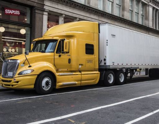 10 TRUCK-DRIVING SAFETY TIPS yellow transport truck parked downtown