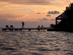 Luxurious and Secluded Escapes in Belize couple on a dock at sunset in Belize