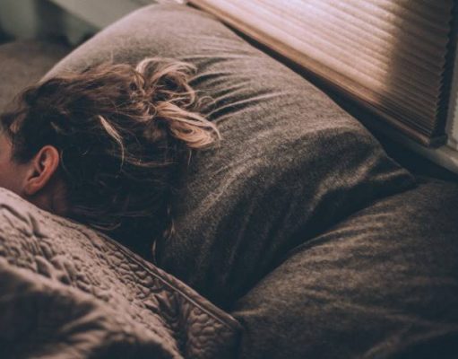 Find Out How to Get Enough Quality Sleep While Travelling girl sleeping in a bed while travelling