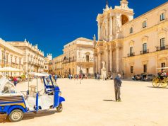 Exclusive Rental Properties Situated in Sicily View of The Cathedral of Syracuse and the central square (Piazza Duomo) with walking people