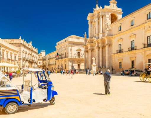 Exclusive Rental Properties Situated in Sicily View of The Cathedral of Syracuse and the central square (Piazza Duomo) with walking people