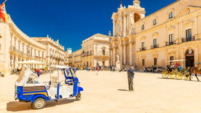 View of The Cathedral of Syracuse and the central square (Piazza Duomo) with walking people