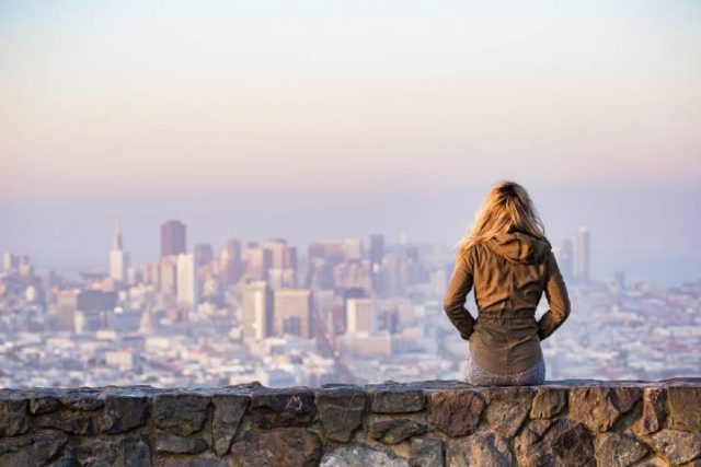 sitting on a wall looking a city