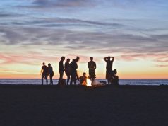 The Best Smokeless Fire Pits for Camping people standing around a fire pit at sunset
