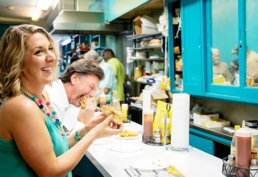 Foodie Travel | Alabama, a Must-Try Destination lady eating a hotdog in a diner