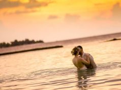 Happily Ever After Begins At Aitken Spence Hotels’ Maldives Resorts coupe standing in the ocean and kissing on their wedding