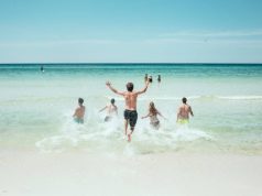 4 Smart Travel Safety Tips That You Should Know for Your Next Vacation people running in to the water on a beach
