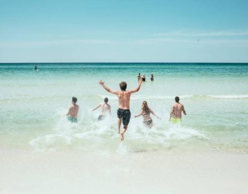 4 Smart Travel Safety Tips That You Should Know for Your Next Vacation people running in to the water on a beach