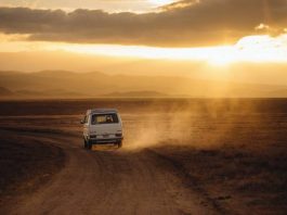 miini camper van driving down a dirt road