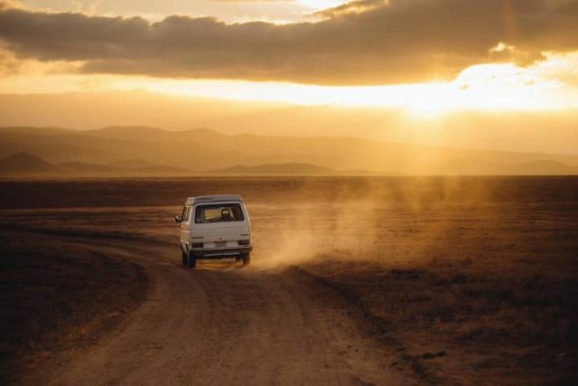 miini camper van driving down a dirt road