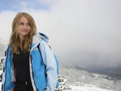 Top 5 Travel Gear You Need Most When Travelling To Colder Climates girl in winter with a blue ski jacket