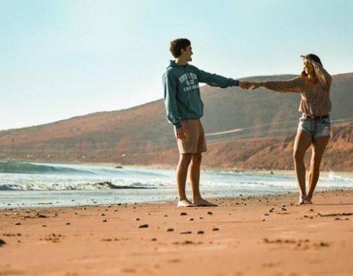 How to Plan the Perfect 420-Friendly Vacation couple walking on the beach holding hands