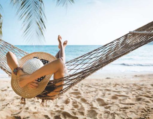 How to Plan Safe and Fun Travel Getaways in 2022 girl in a hammok on the beach