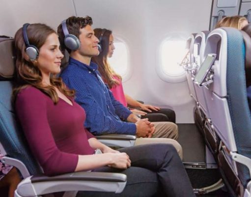 Hawaiian Airlines to Offer Free, High-Speed Starlink Internet Connectivity on Transpacific Fleet passengers on an airplane with headphones