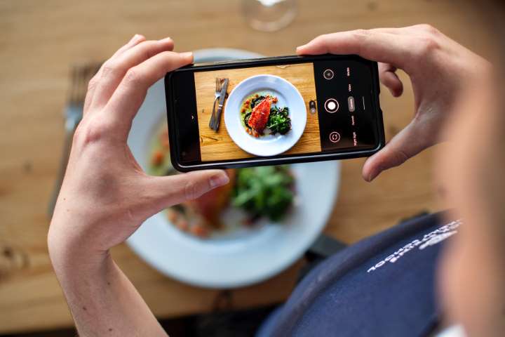 Foodie taking a photo of cooking school dish