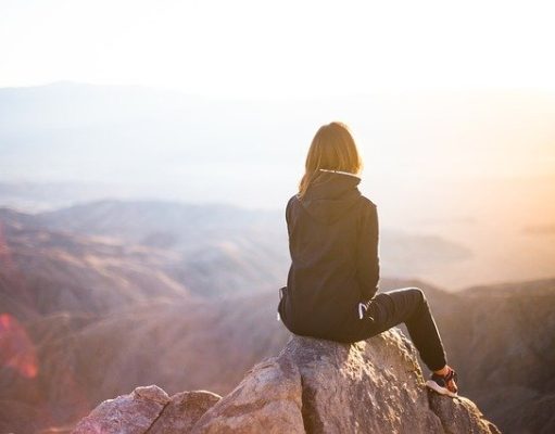5 Best Adventure Travel Destinations for 2022 Woman Travel adventure on a mountain sitting on a rock