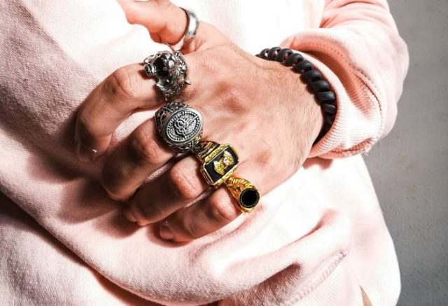 mans hand with many rings