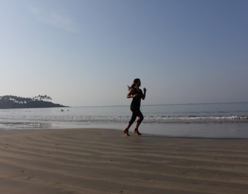 Places to Exercise when You’re on the Road girl running on the beach at sunrise