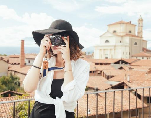 10 Gifts For People Who Love To Travel girl traveling with camera taking photo