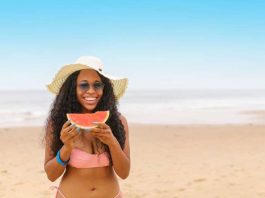 girl on beach eating watermelon