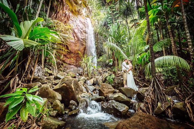 Couple holding hands by waterfall