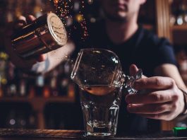 bartender adding spice to brandy cocktail