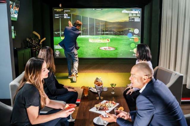 People enjoying dinner and golf simulator