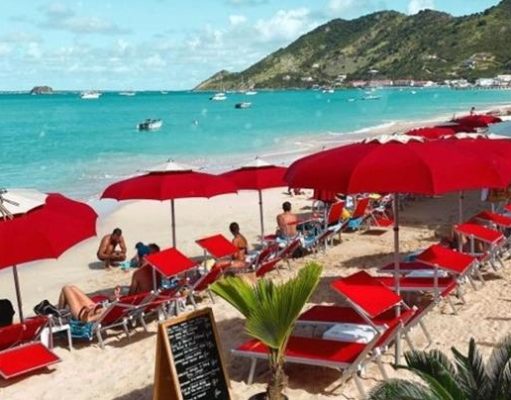 A Vacation Within a Vacation: A Guide to Island Hopping Around St. Martin People on beach at resort in St. Martin