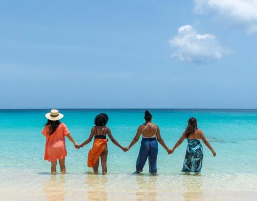 Charming Villas for a Memorable Bachelorette Getaway in Anguilla 4 people holding hands in the ocean beach