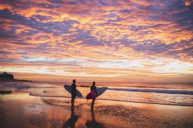 Surfers enjoying a morning in the water off Nobbys Beach, Newcastle.