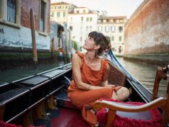 Booking.com’s Seven Predictions for the Creative Reimagination of Travel in 2023 A young woman rides a gondola through Venice