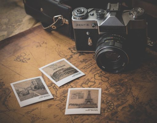 Effective Ways To Make Your Travel Budget Go Further travel photos and camera on a table