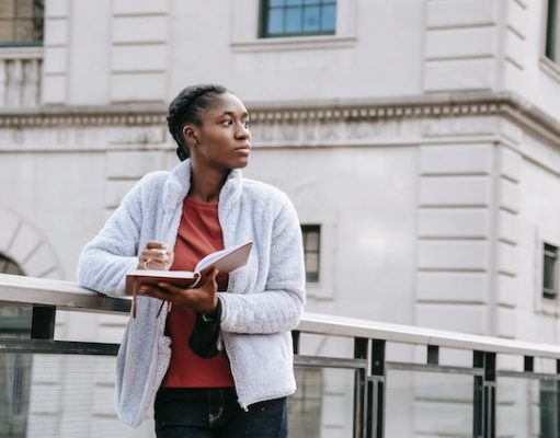 5 Must-Dos Before Moving into Student Accommodation girl reading a book on a bridge