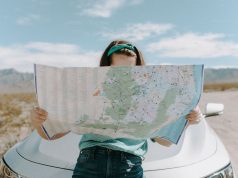 5 Different Ways to Fund Time Off from Work So You Can Travel girl traveling looking at map