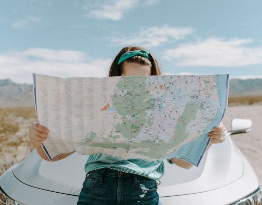 5 Different Ways to Fund Time Off from Work So You Can Travel girl traveling looking at map