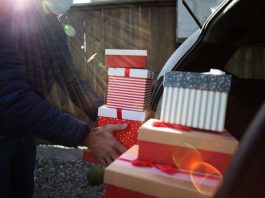 man packing Christmas gift boxes in car