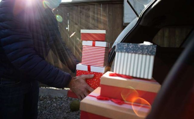 Man packing Christmas gift boxes in the car