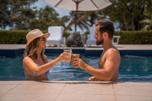 couple having cocktails by a resort pool