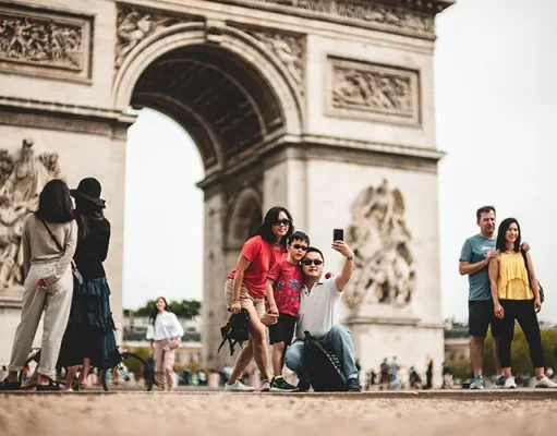 How to Make Your Travel Photos More Outstanding Tourists taking a selfie in frot of the Arc de Triomphe de l'Étoile