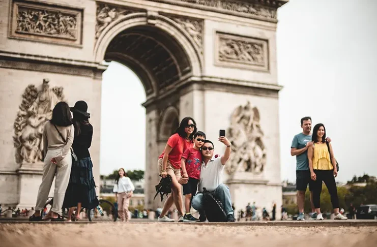 Tourists taking a selfie in frot of the Arc de Triomphe de l'Étoile